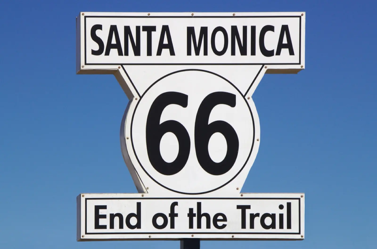 Santa Monica 66 End of the Trail sign against a clear blue sky