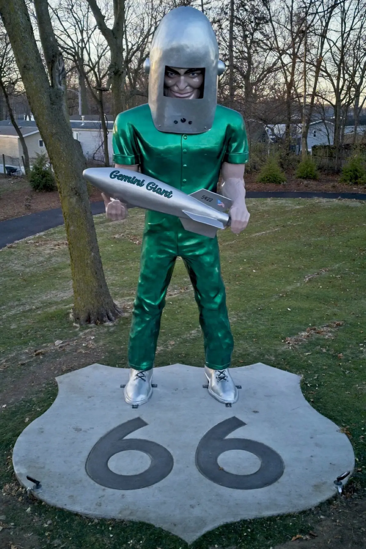 The Gemini Giant, a tall green fiberglass astronaut holding a rocket, standing on a Route 66 shield base in a park in Wilmington, Illinois