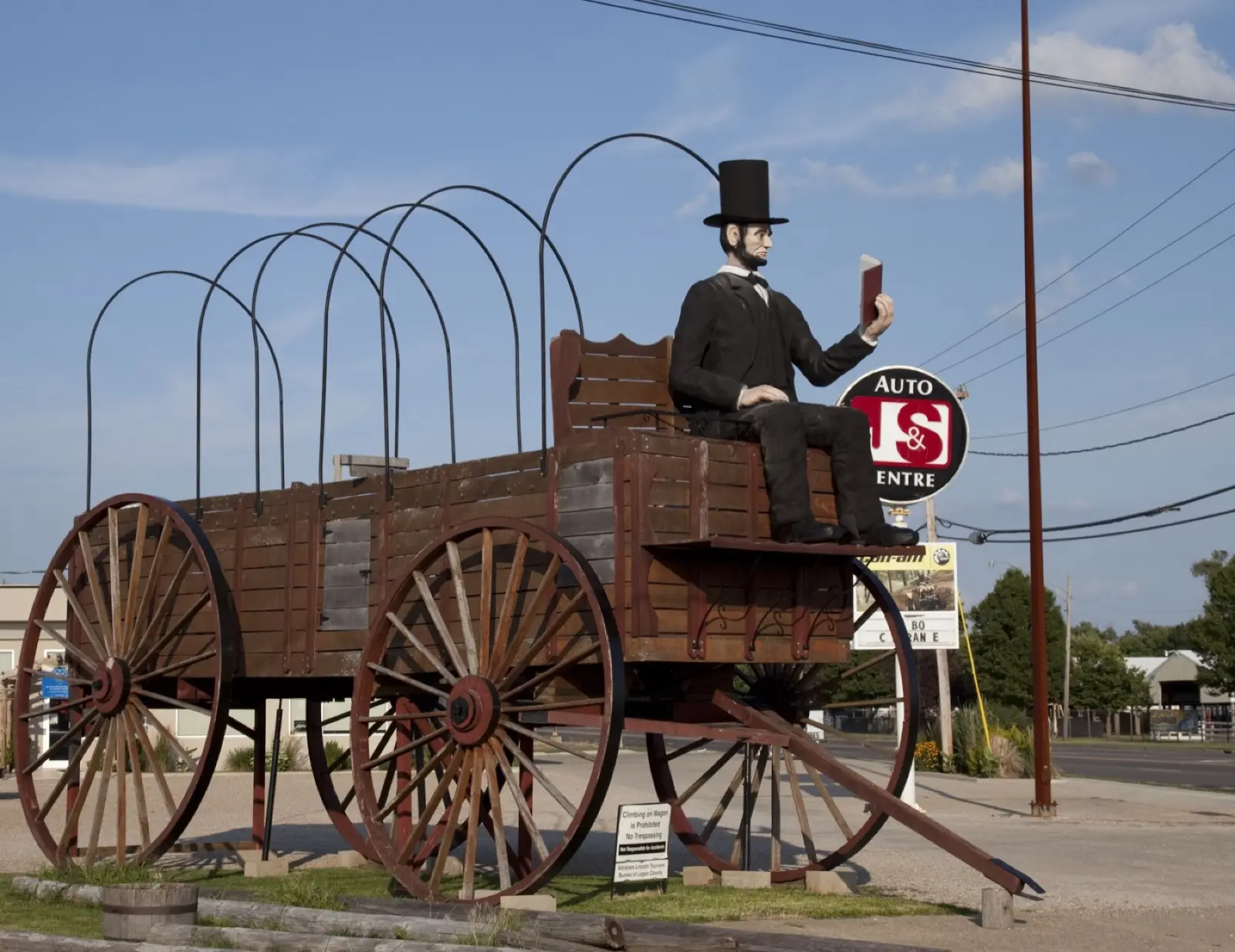 The giant Railsplitter Covered Wagon in Lincoln, Illinois, with a fiberglass Abraham Lincoln in a top hat reading a book on the driver's bench
