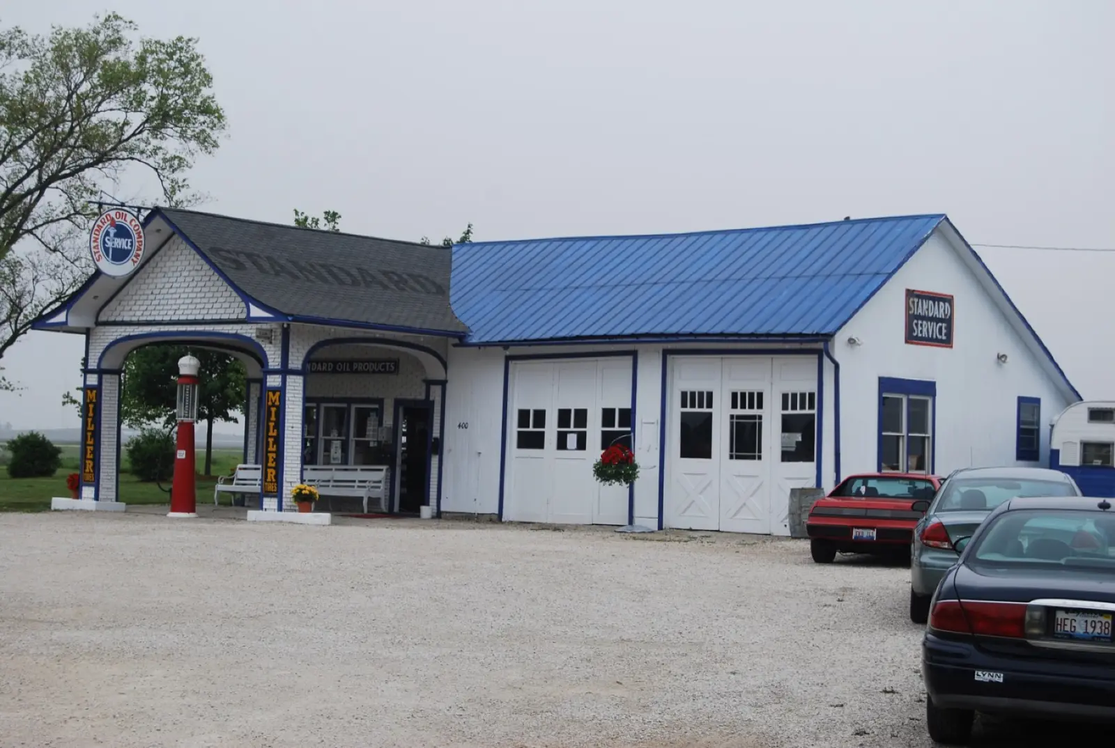 The restored white Standard Oil gas station in Odell, Illinois, with a blue roof, a red visible-register gas pump under the canopy and a Standard Service sign