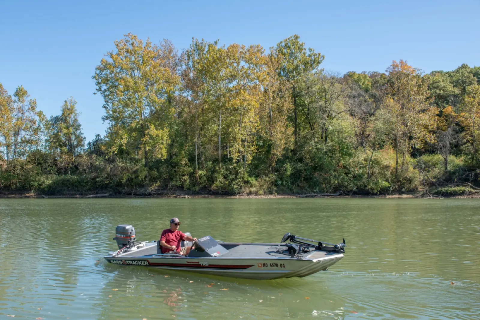 A small fishing boat on the Meramec River at Route 66 State Park in Missouri, with riverside trees turning yellow and orange