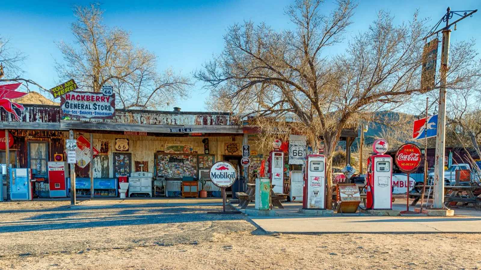 Hackberry General Store on Route 66 in Arizona with old gas pumps, a Mobiloil sign and bare winter trees under a clear blue sky