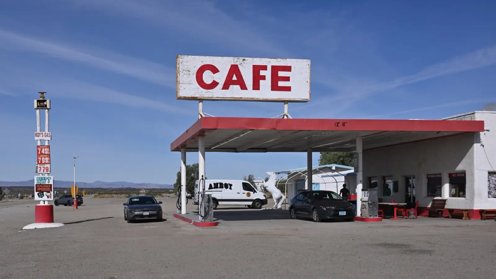 Roy's Cafe in Amboy, California, with its tall CAFE sign over the fuel canopy and the desert behind