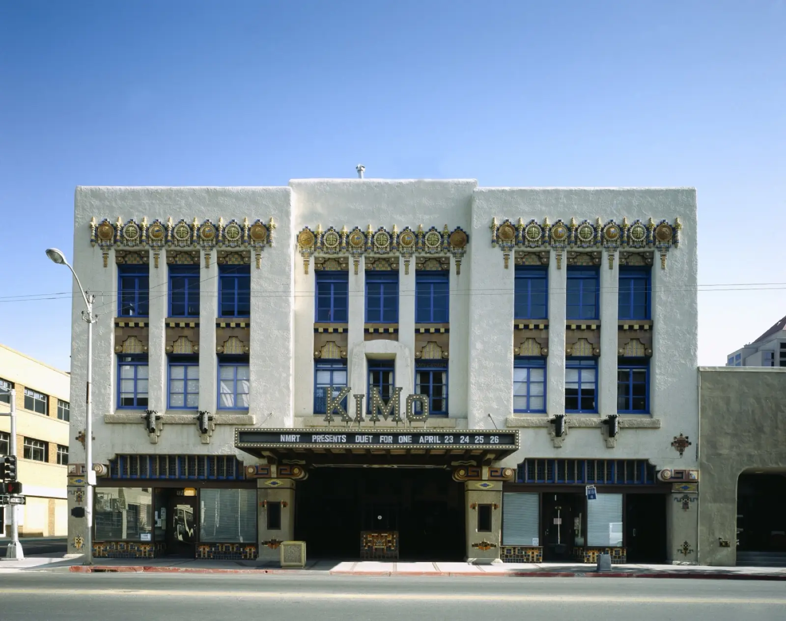 White Pueblo Deco facade of the KiMo Theatre on Central Avenue, Albuquerque, with ornate tile trim and blue windows