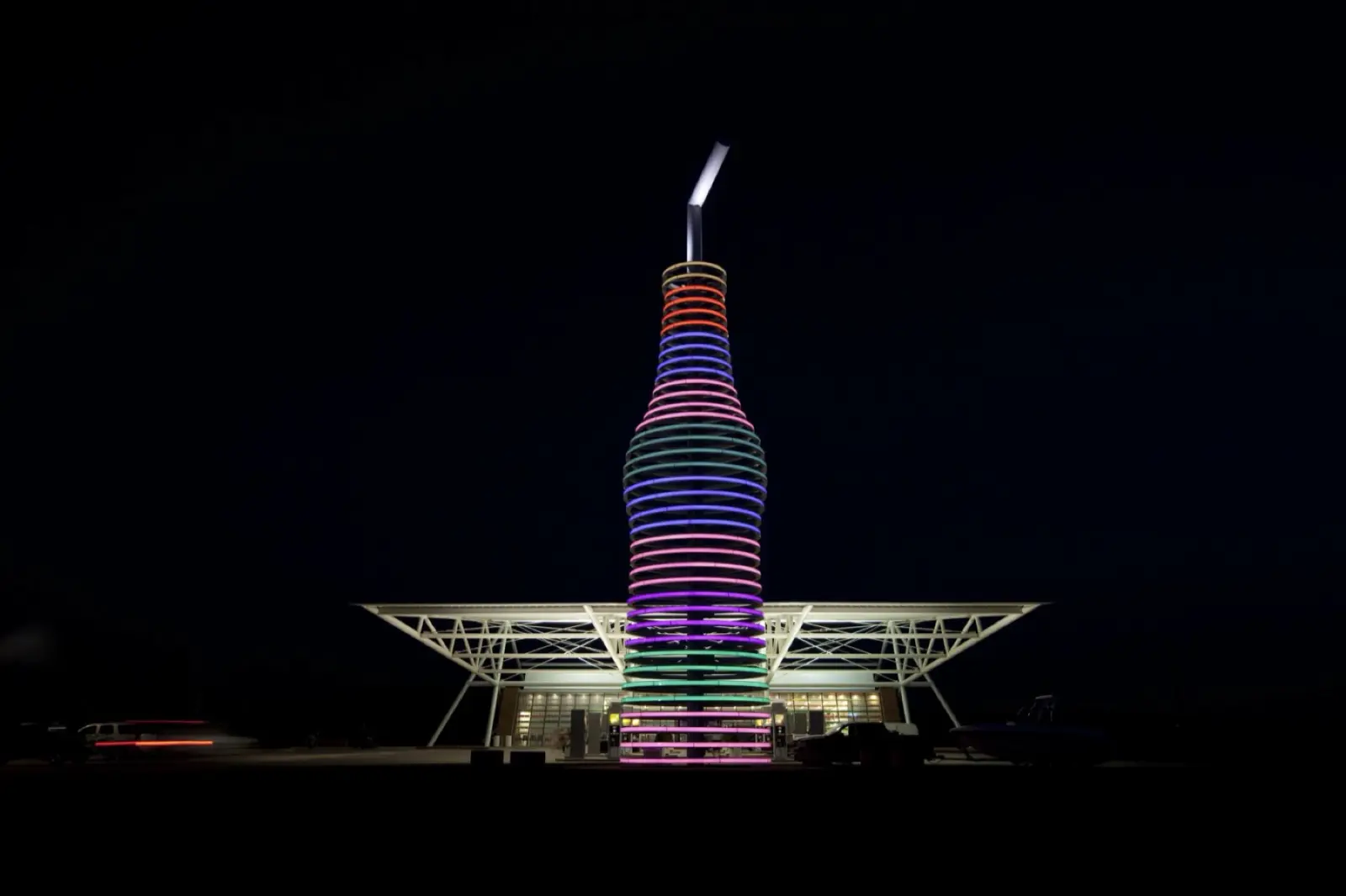 The 66-foot soda bottle sign at POPS in Arcadia, Oklahoma, lit in rings of colored light at night