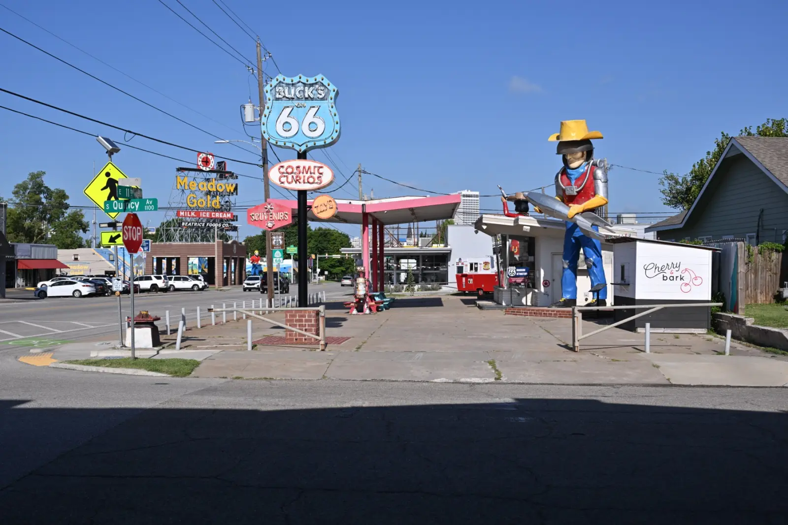 Buck Atom's Cosmic Curios on East 11th Street in Tulsa, with the giant space cowboy holding a rocket, the Buck's on 66 shield sign and the Meadow Gold neon sign behind